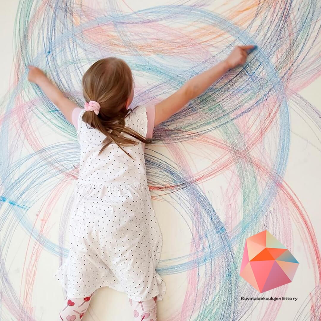 Tyttö piirtää seinälle isoja ympyröitä värikynillä.