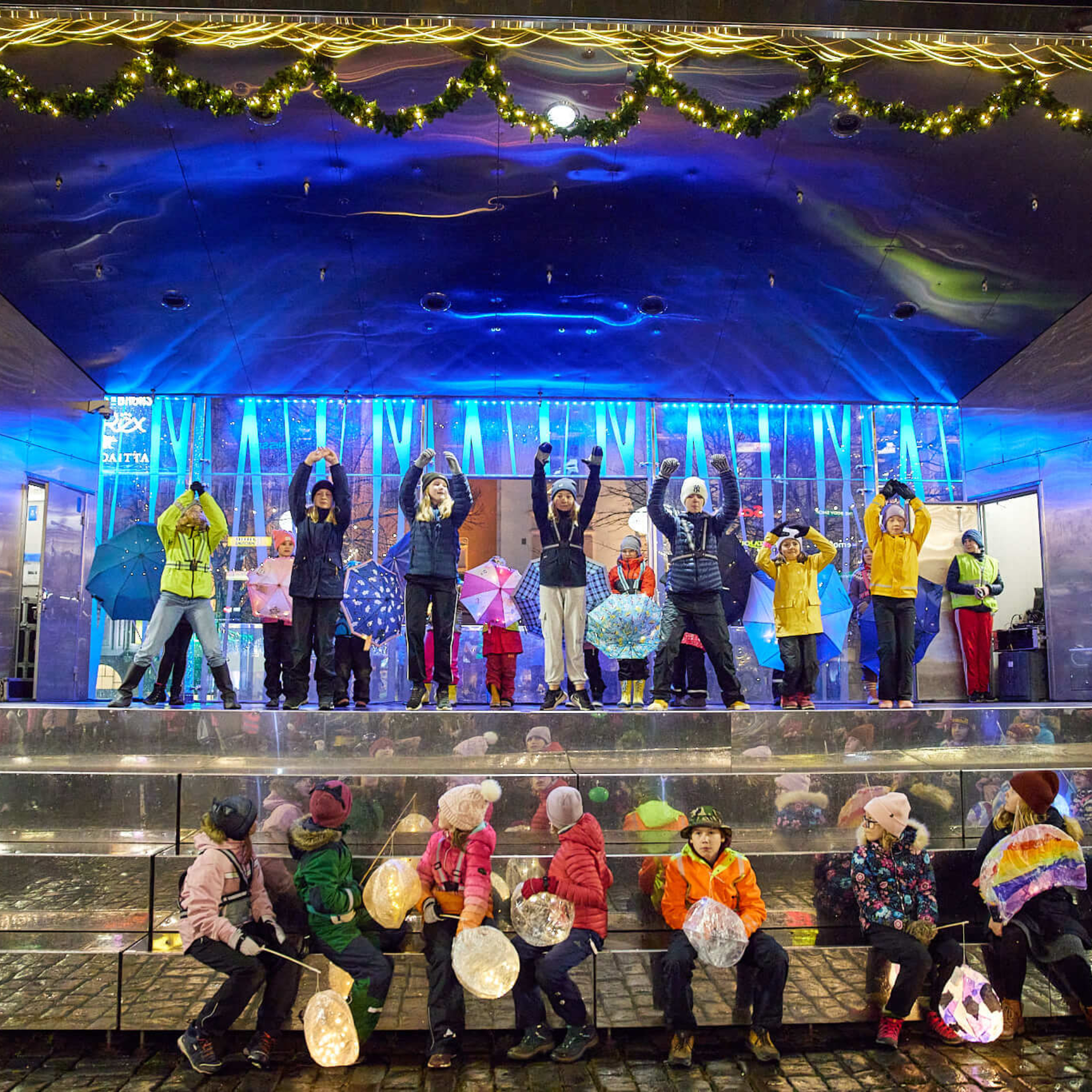 Lapsia esiintymässä värikkäästi valaistulla esiintymislavalla TaiKonin Lapsen oikeuksien päivän Valo- Ljus -tapahtumassa.
