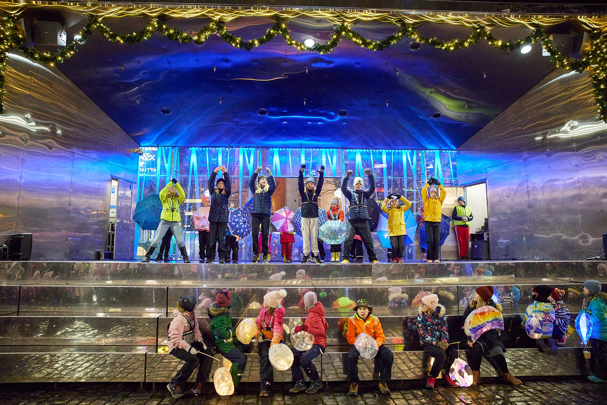Lapsia esiintymässä värikkäästi valaistulla esiintymislavalla TaiKonin Lapsen oikeuksien päivän Valo- Ljus -tapahtumassa.