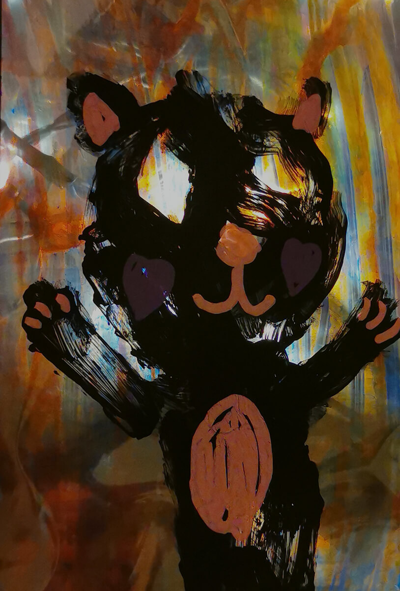 Takaa valaistu, läpikuultavalle pinnalle lapsen maalaama musta nallekarhu.