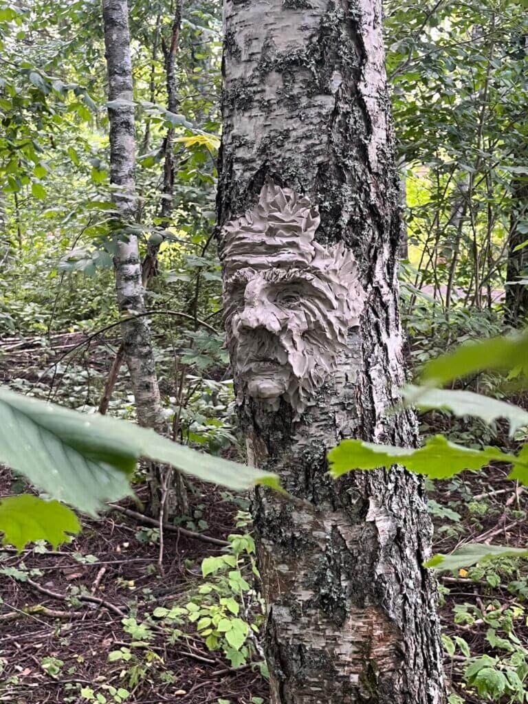Koivun runkoon savesta tai vastaavasta massasta tehty kolmiulotteinen taideteos, joka esittää ihmisen kasvoja.