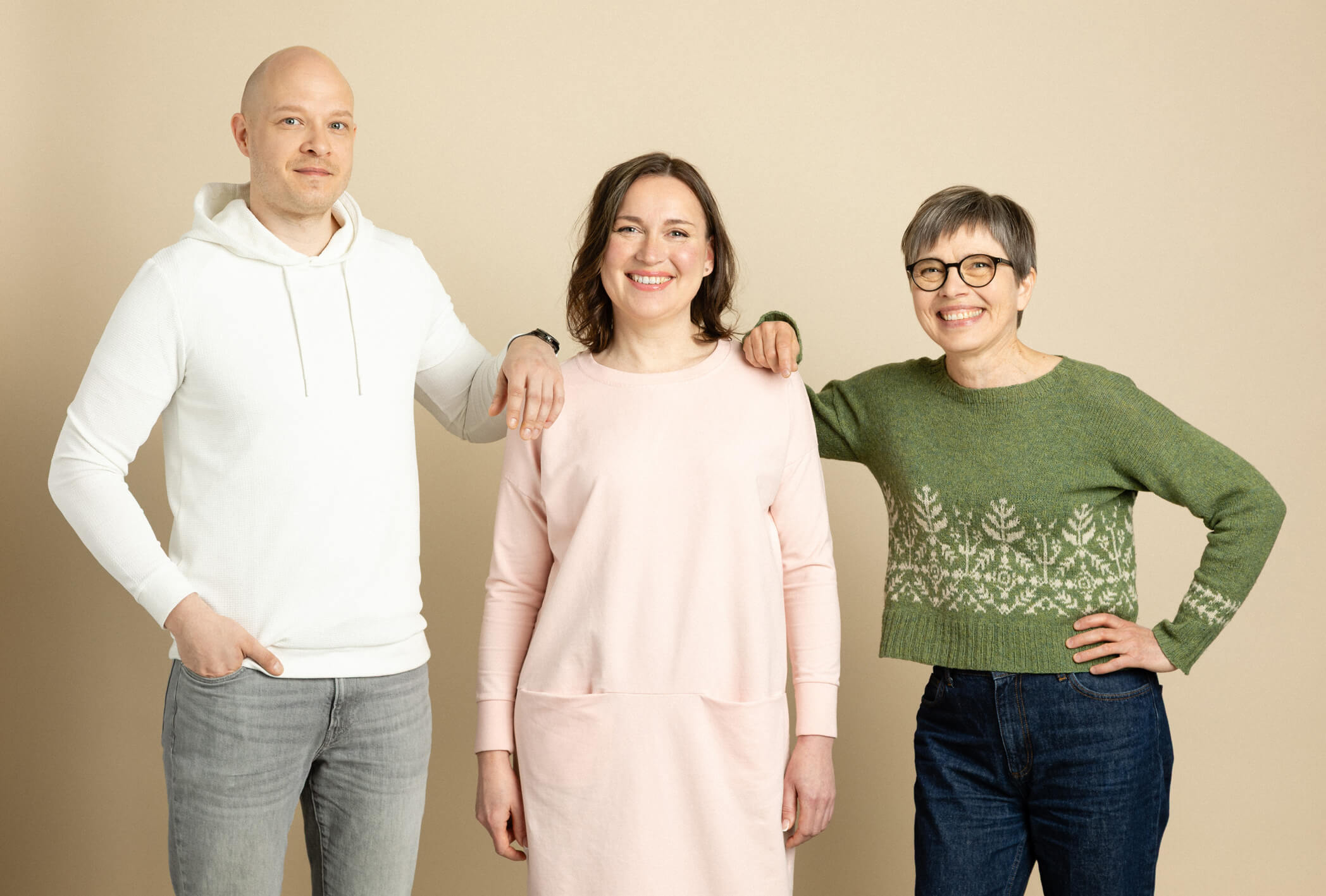 Hymyilevät mies ja kaksi naista katsovat kameraan.